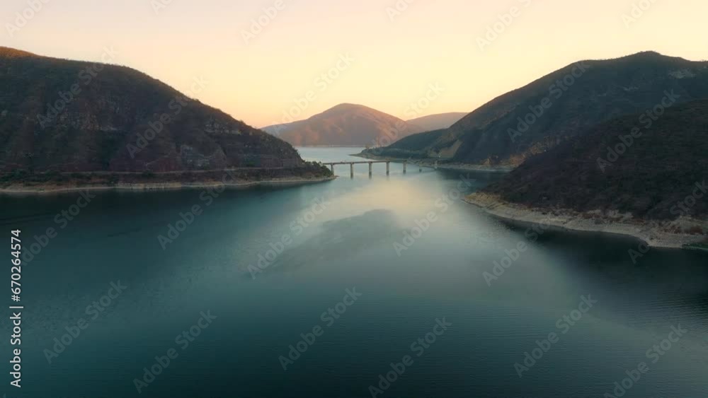 Aerial drone flying over a lake, water dam, with mountains and a bridge at sunrise. Beautifull dreamy landscape view. Coastline with boats. Pacefull landscape. Cabra Corral, Salta, Argentina. Aerial drone flying over a lake, water dam, with mountains and a bridge at sunrise. Beautifull dreamy landscape view. Coastline with boats. Pacefull landscape. Cabra Corral, Salta, Argentina.