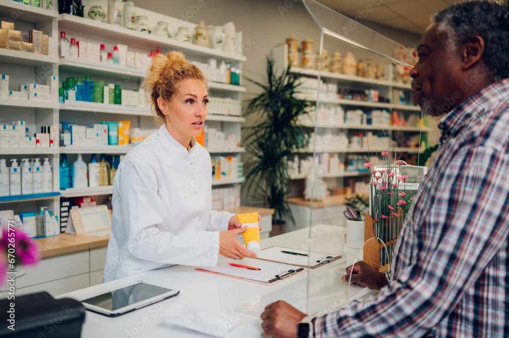 Woman pharmacist selling drugs to a senior patient customer in a pharmacy