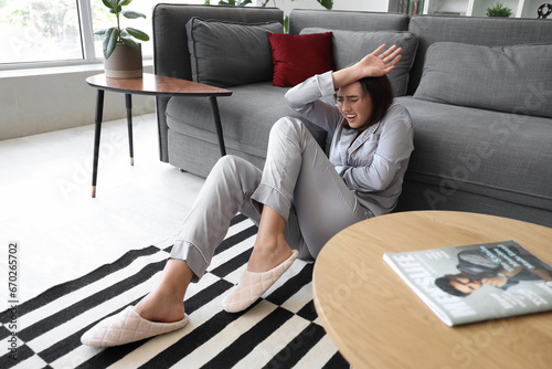 Photos Beautiful young afraid woman sitting on floor in living room
