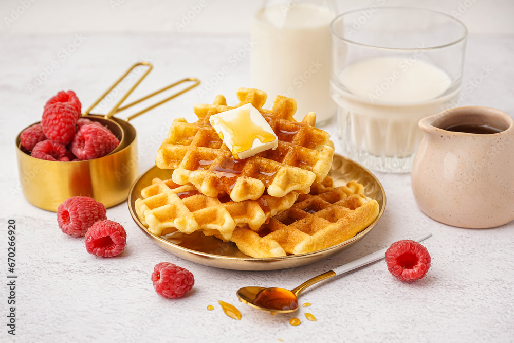 Plate of tasty waffles with raspberries and maple syrup on white background Plate of tasty waffles with raspberries and maple syrup on white background