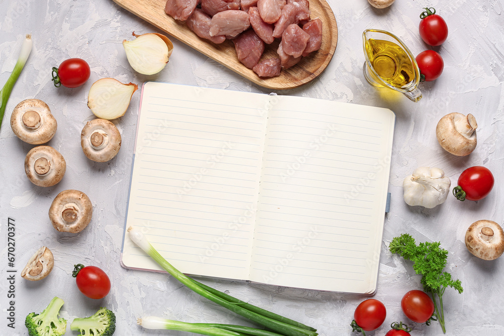 Composition with blank recipe book, vegetables and raw meat on light background Composition with blank recipe book, vegetables and raw meat on light background
