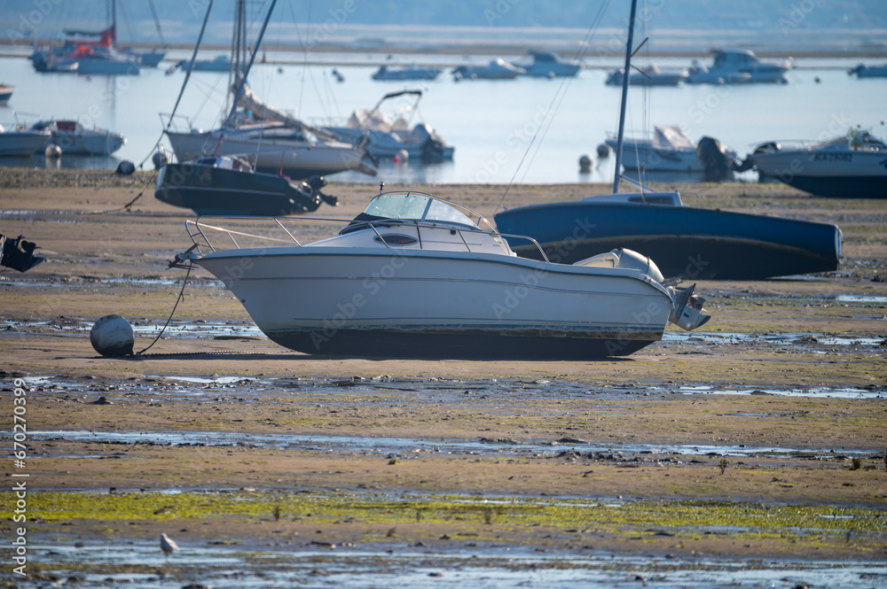 Obraz premium View on Arcachon Bay at low tide with many fisherman's boats and oysters farms, Cap Ferret peninsula, France, southwest of Bordeaux along France's Atlantic coastline