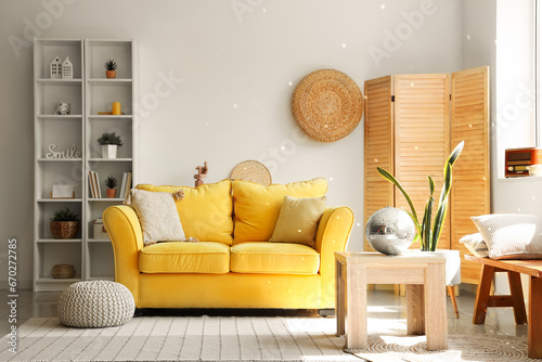 Interior of modern living room with yellow sofa and disco ball on coffee table photo