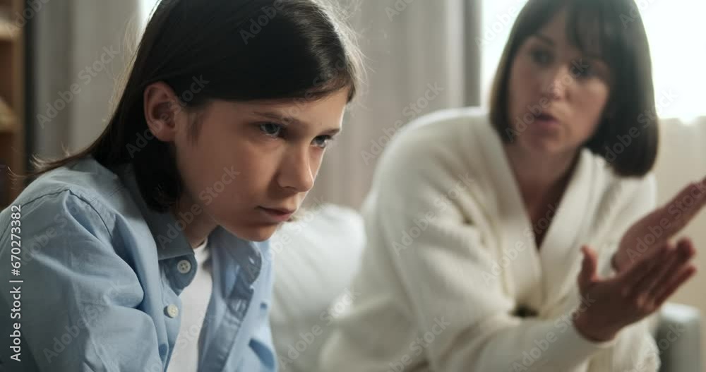 Portrait captures a young boy with mother scolding him in the background. The boy expression carries a mix of emotions, illustrating a challenging moment of parental guidance. Portrait captures a young boy with mother scolding him in the background. The boy expression carries a mix of emotions, illustrating a challenging moment of parental guidance.