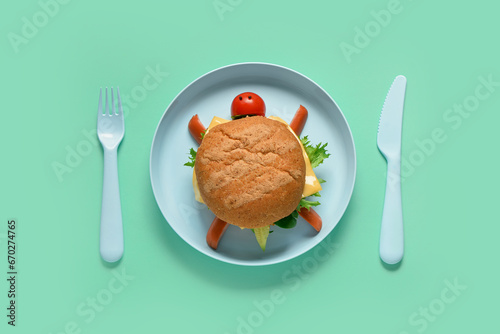 Plate with funny children's breakfast in shape of turtle on turquoise background