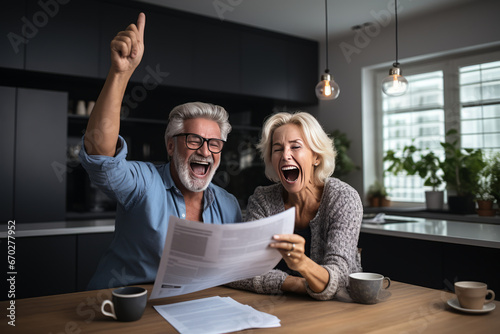 Excited mature couple celebrating financial success, reading good news in documents, and giving a high five
