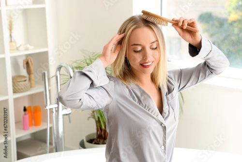 Young blonde woman brushing...