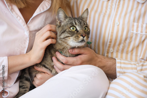 Young couple with cute cat in bedroom, closeup