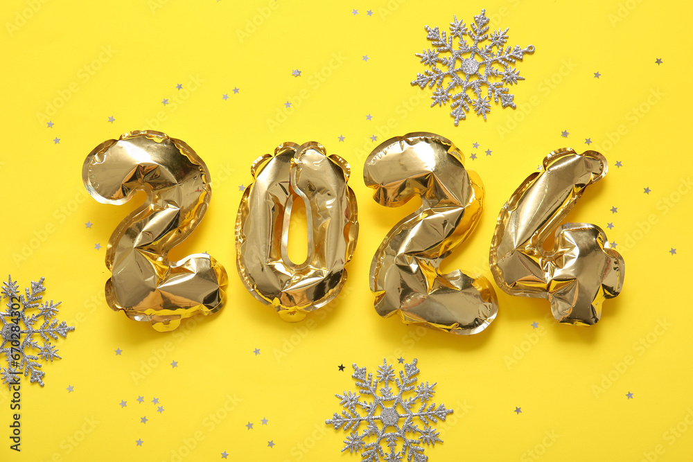 Figure 2024 made of foil balloons with snowflakes and confetti on yellow background Figure 2024 made of foil balloons with snowflakes and confetti on yellow background