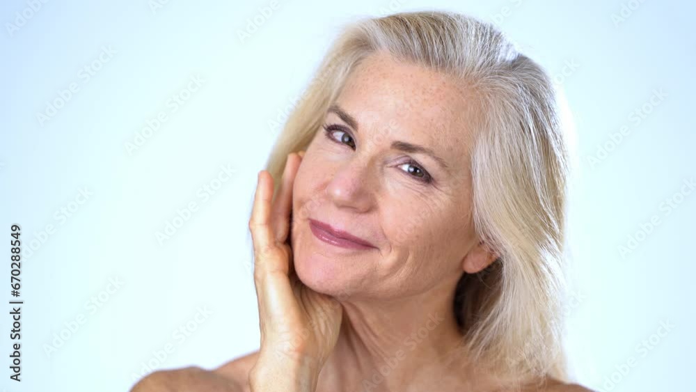 Closeup portrait of happy smiling attractive mature woman nude looking at camera touching face with hand. Advertising body care spa concept. Closeup portrait of happy smiling attractive mature woman nude looking at camera touching face with hand. Advertising body care spa concept.
