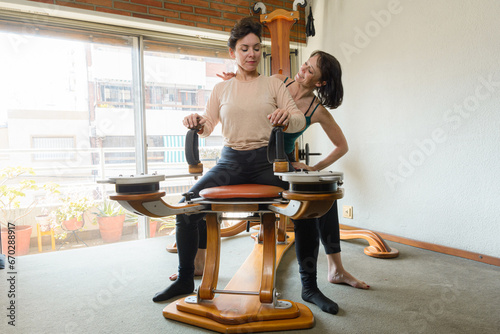 gyrotonic instructor sitting with her student teaching technique and arm movements