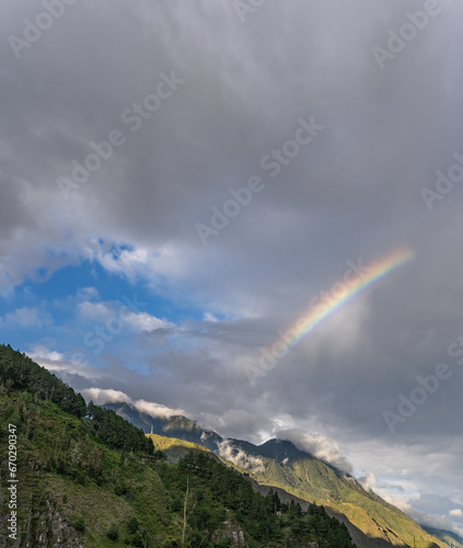 Beautiful view of the rainbow over the volcanoes in the city of Banos, Ecuador. Amazing sunset.