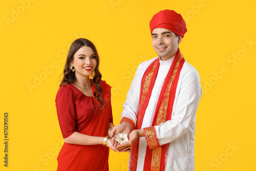 Beautiful Indian couple diya lamp on yellow background