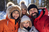A happy latin family is posing playfully in front of the camera with winter coats and wearing winter hats in a in snow covered forest during a bright day in winter on a sunny day