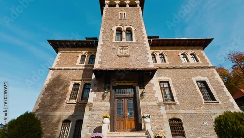 At the staircase to the old beautiful palace with tower. Cantacuzino Castle in Busteni, Romania on sunny day. Low angle view. photo