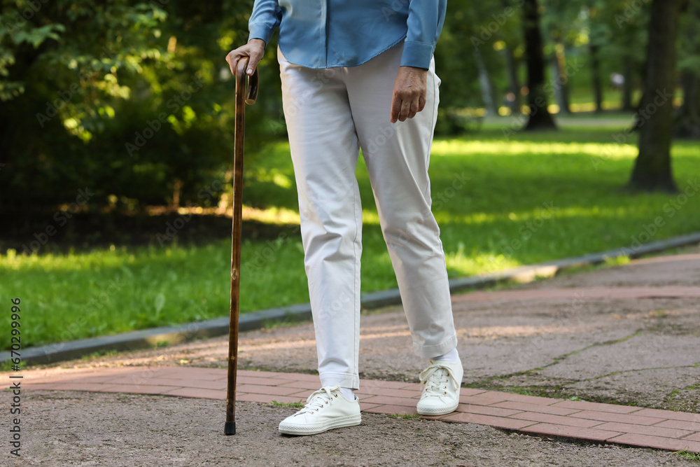 Senior woman with walking cane in park, closeup Senior woman with walking cane in park, closeup