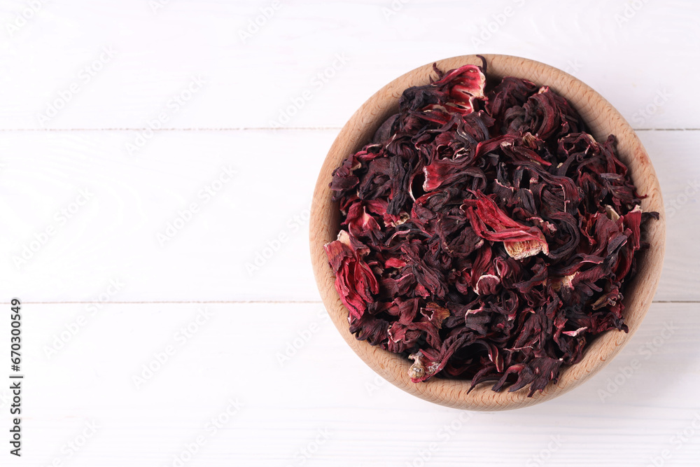 Dry hibiscus tea in bowl on white wooden table, top view. Space for text Dry hibiscus tea in bowl on white wooden table, top view. Space for text