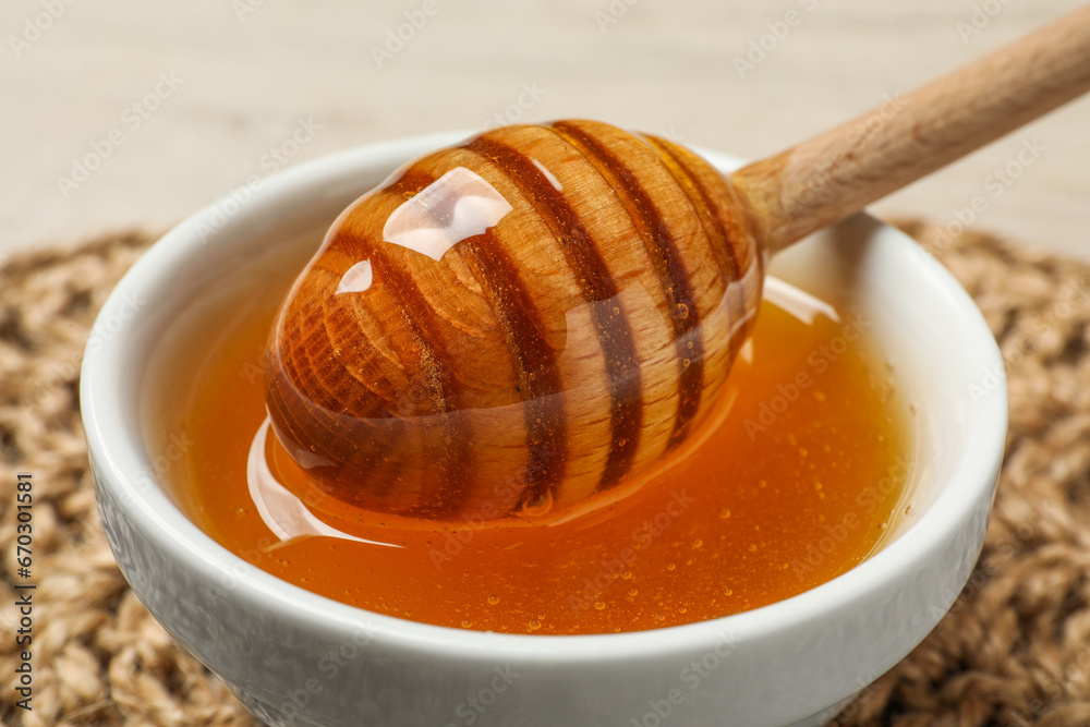 Dipper with honey in bowl on table, closeup Dipper with honey in bowl on table, closeup