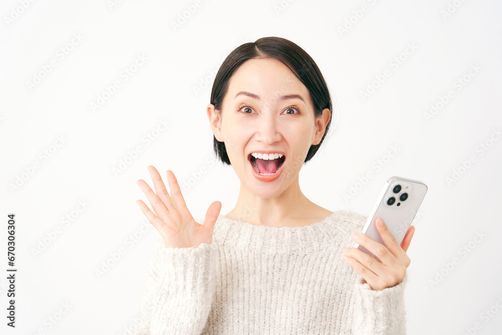 スマートフォンを持って驚く女性　白背景