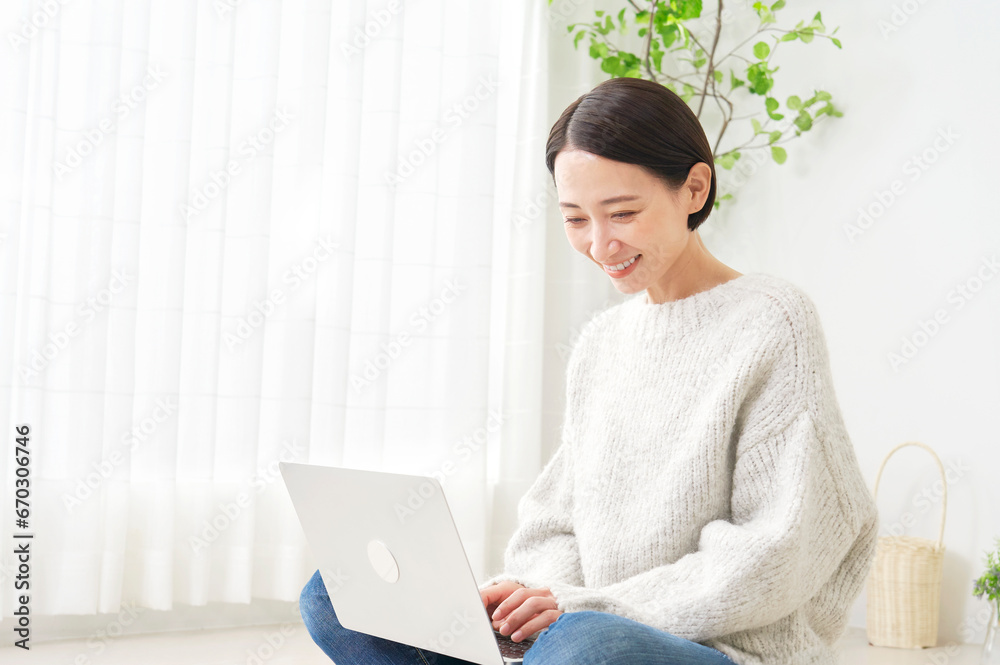 リビングでノートパソコンを使う女性 リビングでノートパソコンを使う女性