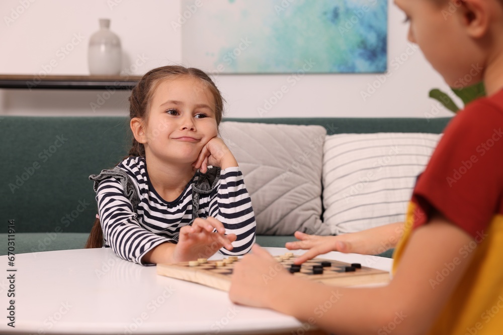 Children playing checkers at coffee table in room Children playing checkers at coffee table in room