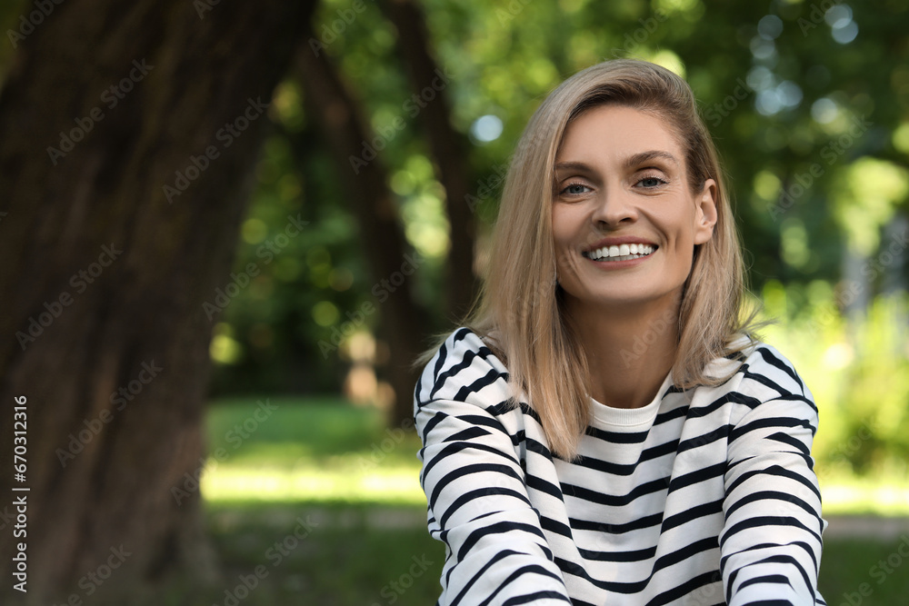Portrait of happy woman in casual clothes outdoors. Space for text. Attractive lady smiling and posing for camera Portrait of happy woman in casual clothes outdoors. Space for text. Attractive lady smiling and posing for camera