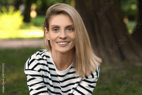 Portrait of happy woman in casual clothes outdoors. Attractive lady smiling and looking into camera