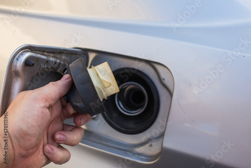 Hand refilling the car with fuel at the refuel station photo