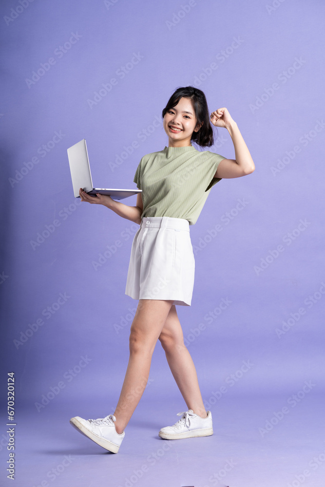 Portrait of beautiful Asian woman posing on purple background