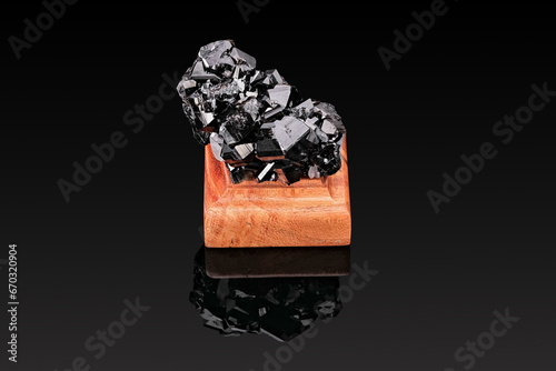 mountain crystal mineral of black color on a stand made of wood