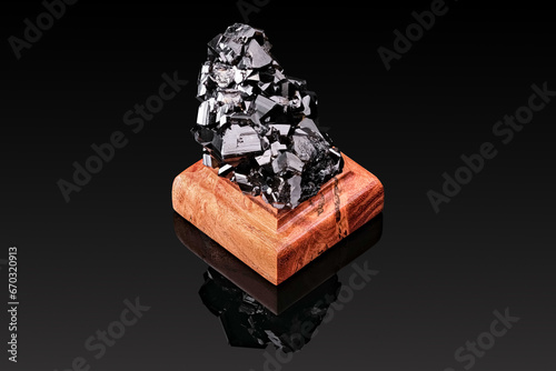 mountain crystal mineral of black color on a stand made of wood