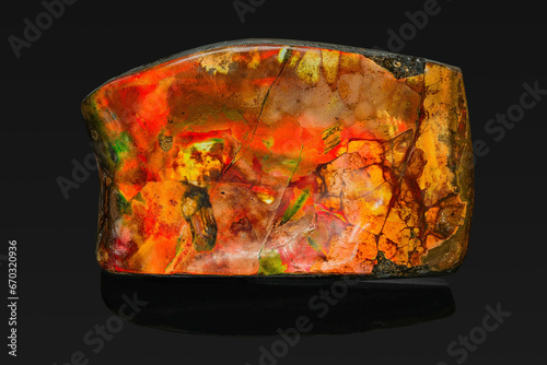 a rock mineral of opalescent color on a black background