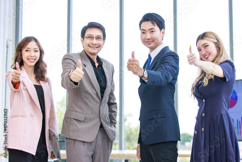 Asian professional successful two male businessmen partnership dealer and customer in formal business suit standing posing with female secretaries in company office meeting room