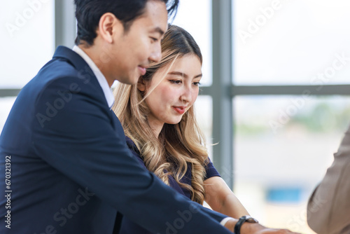 Closeup Asian professional successful male female businessman businesswoman partnership colleagues in formal business suit sitting  in meeting room in company office