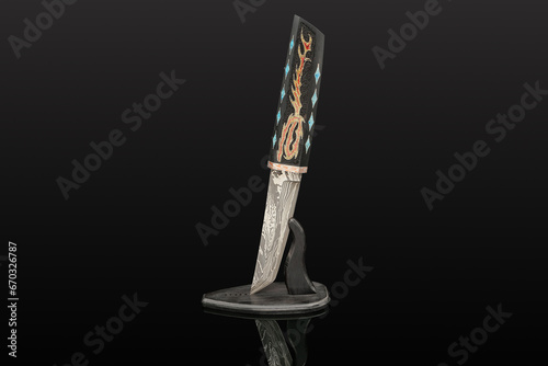 hand-forged Japanese samurai knife tanto with inlays in the form of hieroglyphs in black dener on a black background