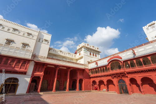 Buildings with red and white facades under blue sky and white clouds. Junagarh Fort is located in Bikaner  Rajasthan  India