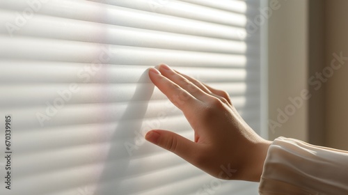 Close-up of a person's hand controlling smart blinds to adjust natural light and privacy