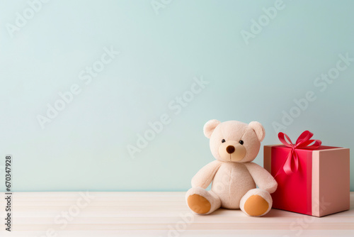 Soft Teddy Bear with Red Gift Box on Pastel Blue Background, Copy Space