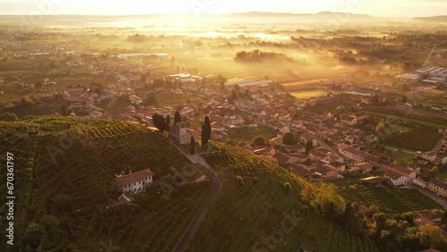 Aerial landscape view over the famous prosecco hills with vineyard rows, Italy, on a misty morning sunrise photo