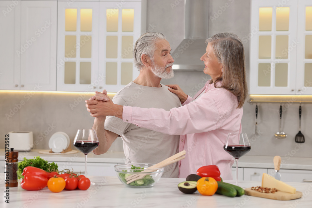 Happy affectionate senior couple dancing in kitchen Happy affectionate senior couple dancing in kitchen