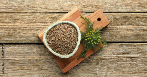 Dill seeds in bowl on wooden table, top view. Banner design