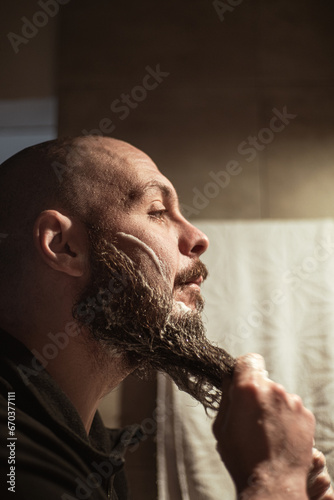 Washing beard. Man washing his beard with foam. Beard care.