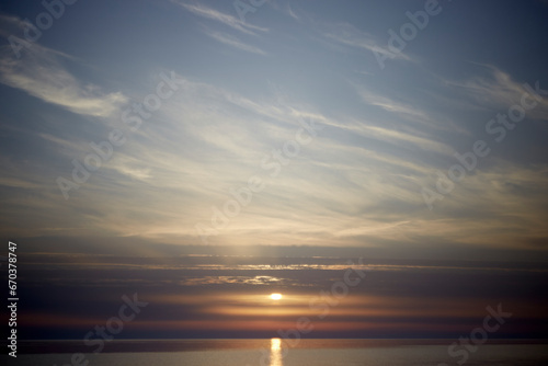 Amazing scenery with sky coloured by the sunset reflecting the calm sea water, selective focus