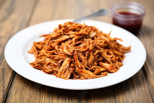 shredded chicken tossed in bourbon bbq sauce on a white plate