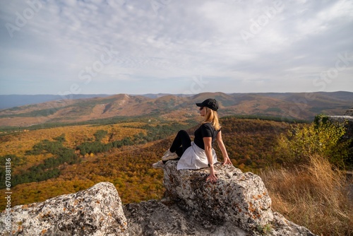 woman on mountain peak looking in beautiful mountain valley in autumn. Landscape with sporty young woman, blu sky in fall. Hiking. Nature © svetograph