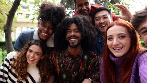 group of smiling multiracial teenage friends taking selfies during a peace march