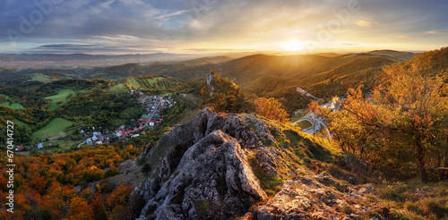 Mountains at sunset in Slovakia - Vrsatec. Landscape with mountain hills orange trees and grass in fall, colorful sky with golden sunbeams. Panorama © TTstudio