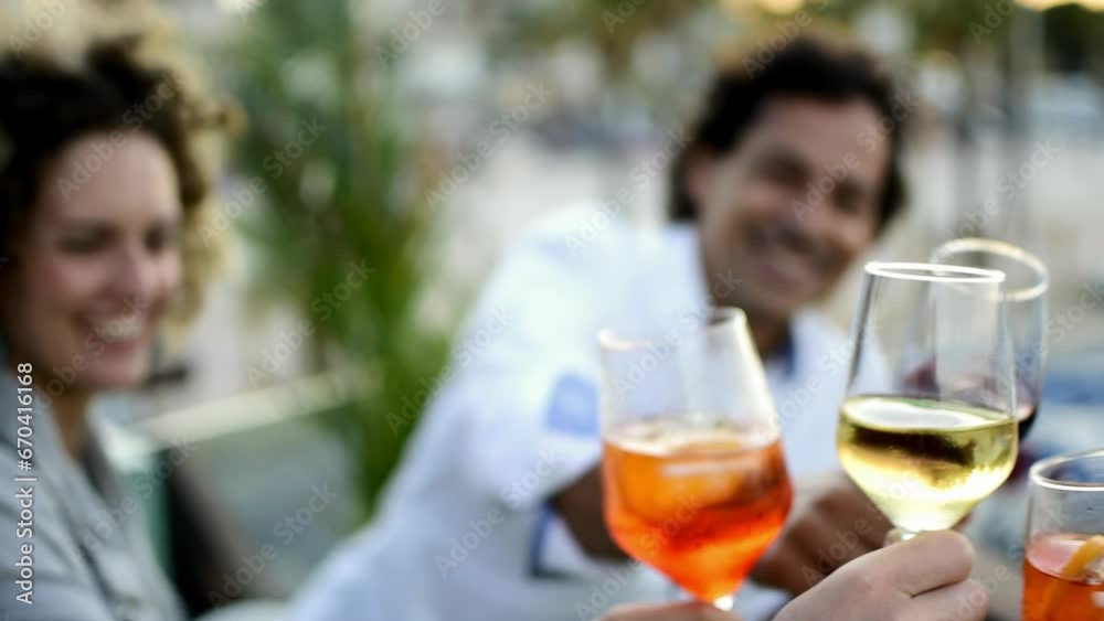 Friends toast cheers drinking glasses at social party event smiling on terrace cheerful