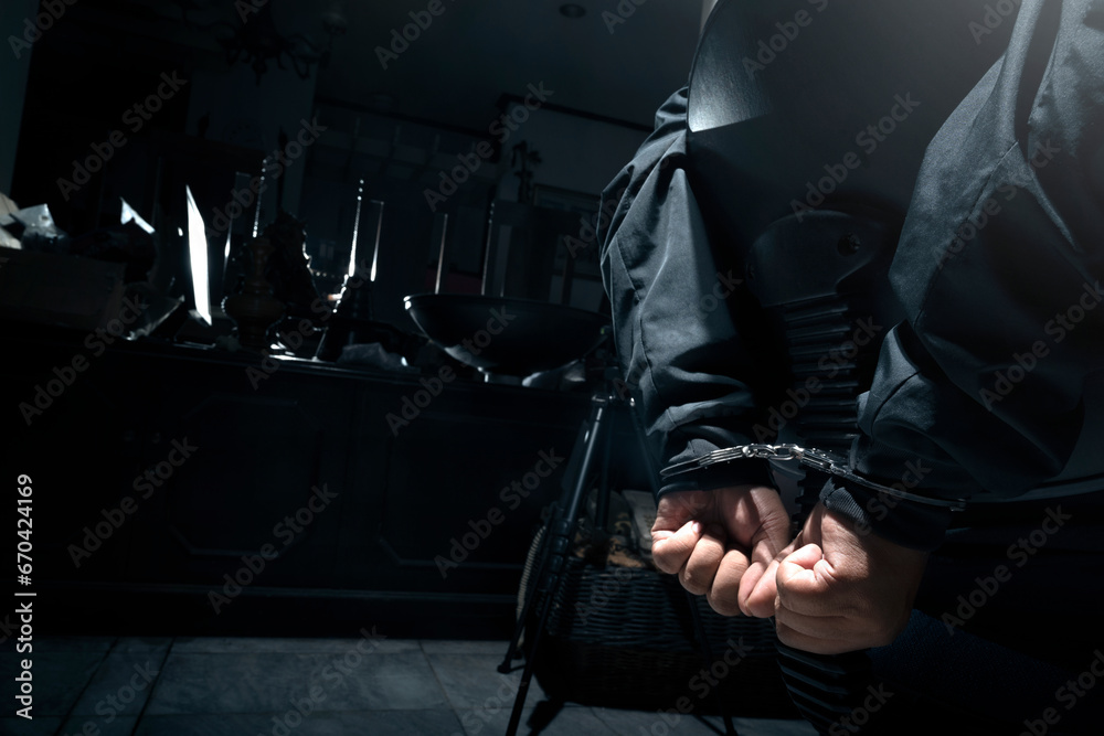 The man was sitting on a chair with tied hands in handcuffs - obrazy, fototapety, plakaty 