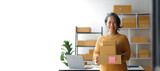 Senior female entrepreneur, small business owner, online seller working with parcel boxes preparing to ship orders from the internet, retirement hobby.